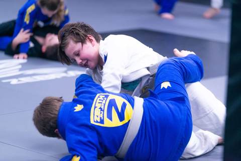 Two children rolling in Team Zenith gis during the kids Brazilian Jiu Jitsu class at Fight For Us Jiu Jitsu